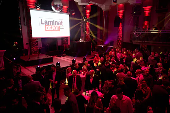 Leinwand mit LaminatDEPOT Logo und Leute bei Firmenfeier