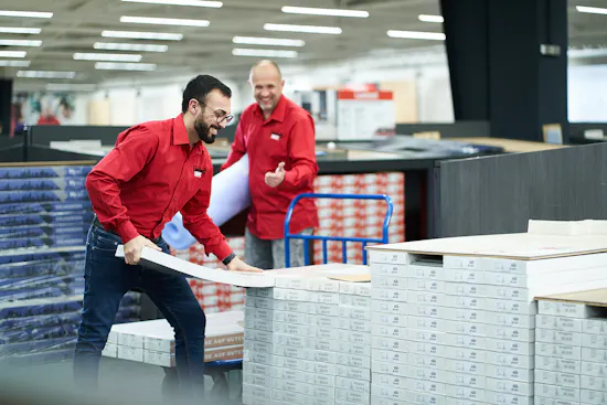 Zwei LaminatDEPOT Mitarbeiter bei der Arbeit beim Paletten stapeln