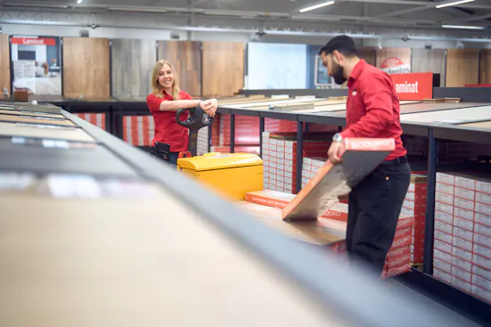 Zwei LaminatDEPOT Auszubildende in der Filiale mit Gabelstapler und Paletten