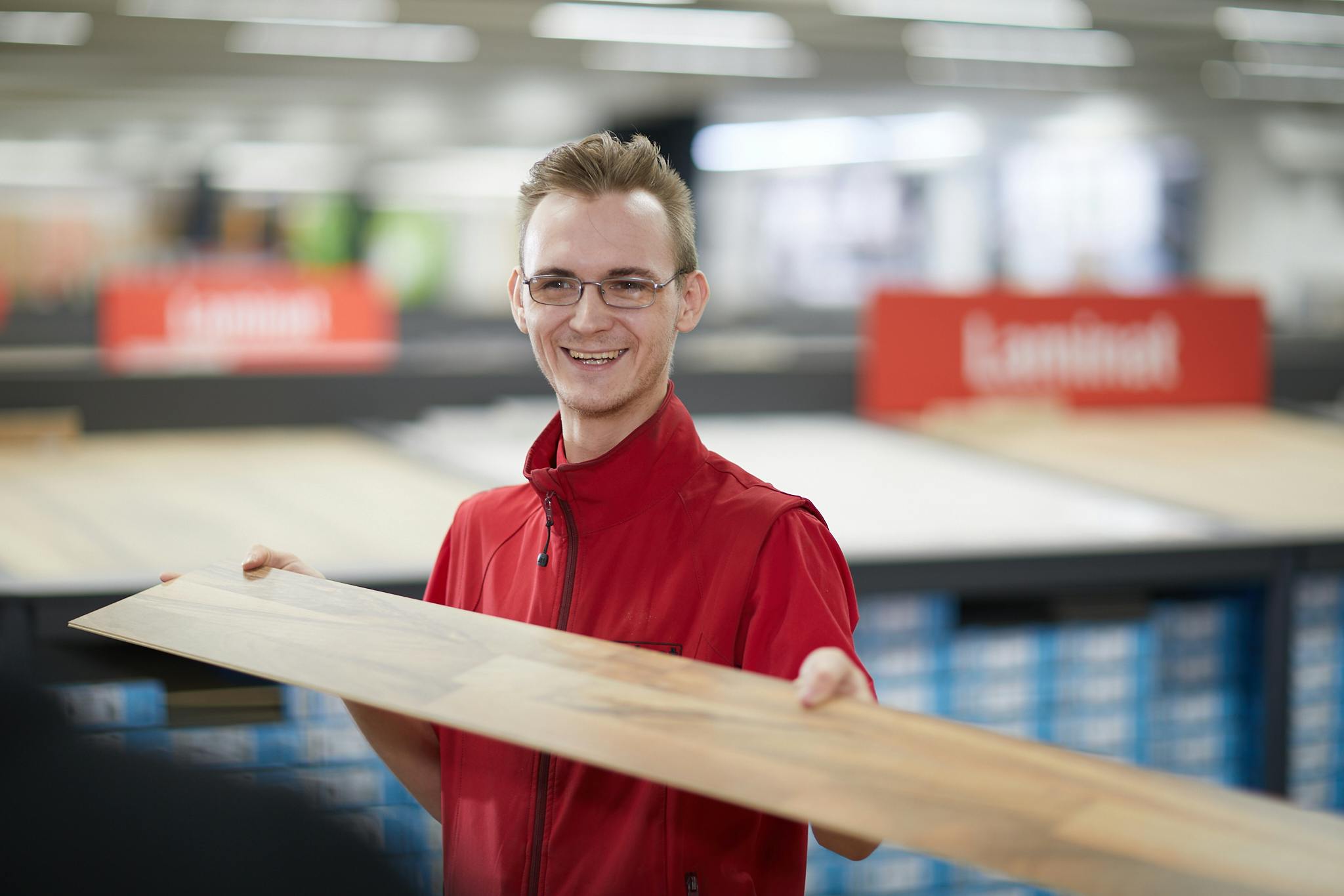Aushilfe von LaminatDEPOT mit Laminatdiele in der Hand