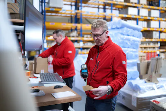 Mann scannt Code im Logistikzentrum
